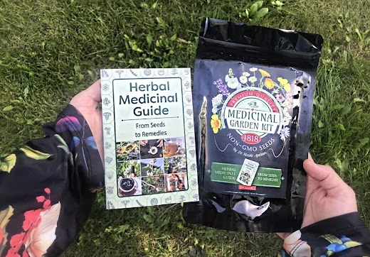 Hands holding Medicinal Garden Kit 4818 non-GMO seeds bag and printed herbal remedy guide